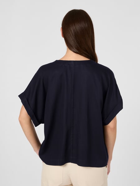 Kortærmet damebluse Natblå, præsenteret på en model