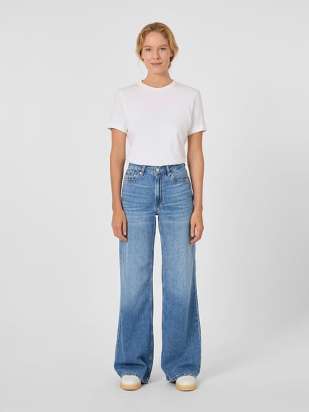 Damejeans med udvidet ben Medium blå, præsenteret på en model