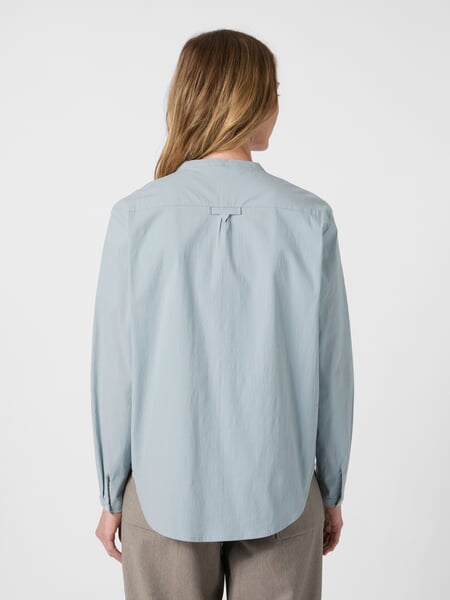 Damebluse med opretstående krave Lyseblå, præsenteret på en model