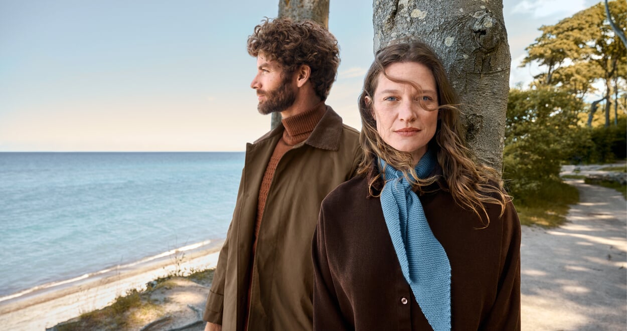 Zwei Models in Herbstkleidung bei Abenddämmerung am Strand