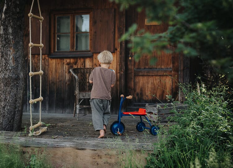 Child with tricycle and rope ladder