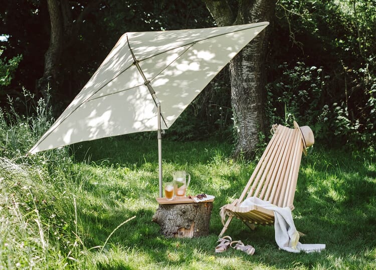 Parasol et chaise longue dans le jardin